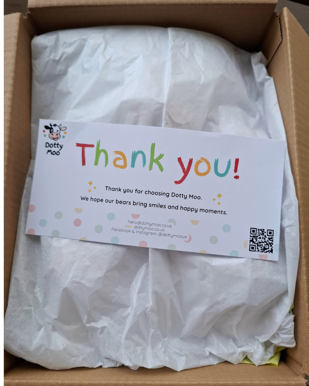 Tissue wrapped gift presentation inside box with thank you card